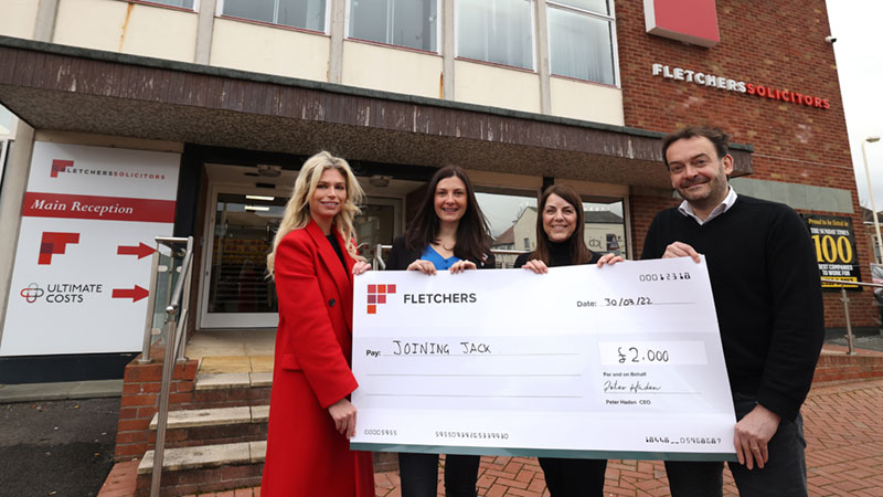 Fletchers solicitors present a cheque to joining Jack